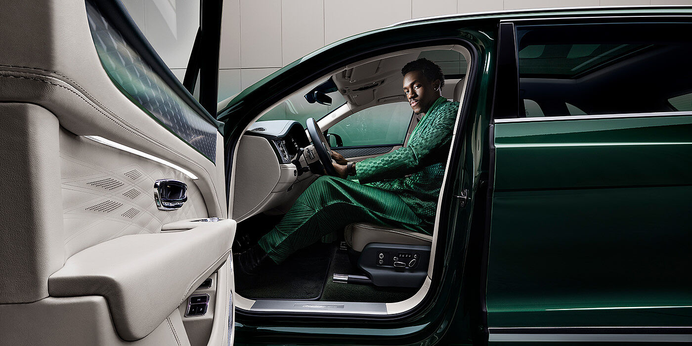 Bentley Bordeaux Wisdom K seated in Bentley Bentayga Extended Wheelbase SUV in Light Emerald green paint with door open